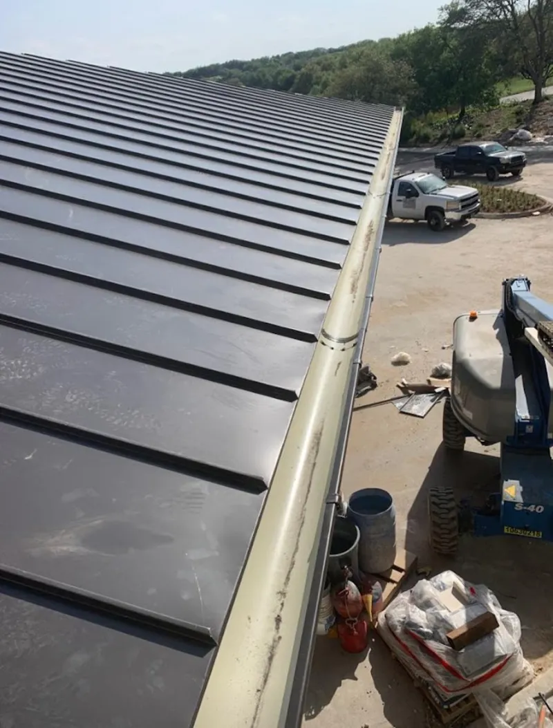 Standing seam panel and gutter detail on a metal roofing jobsite in Fort Gratiot